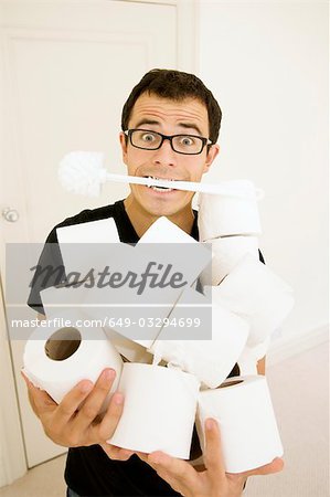 Man with toilet brush and toilet rolls