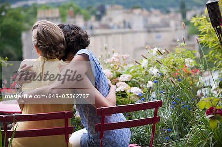 two women hugging on balcony