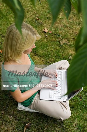 girl on computer in garden girl on computer in garden