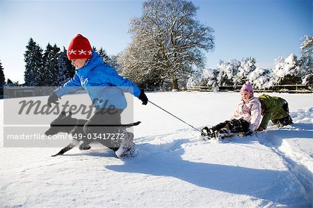 Children playing on sledge in the snow