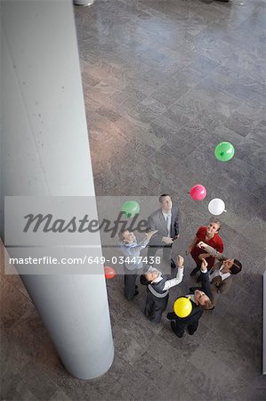 Business team sets colored balloons free