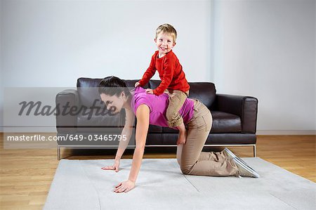 Mother giving boy a piggyback ride