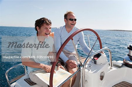 Men navigating yacht