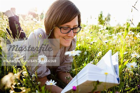 Woman reading book in wild meadows