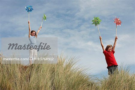 Girls holding windmills up in the sky