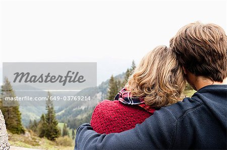 Man hugging woman watching landscape