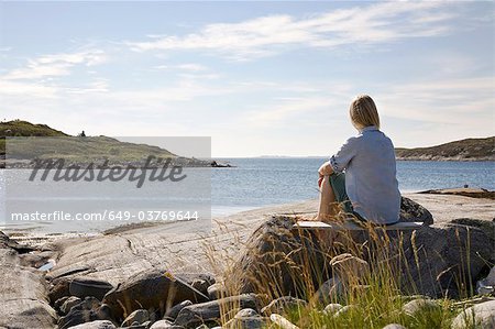 Woman sitting and looking out to sea