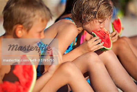 Kids eating watermelon at the beach