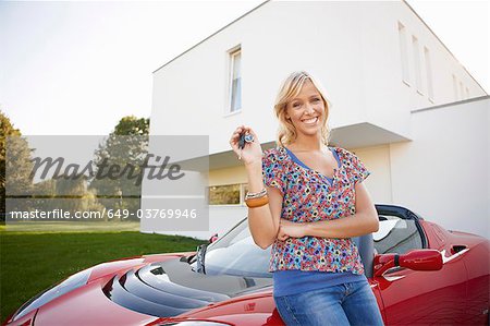 Girl proudly showing her key to a car