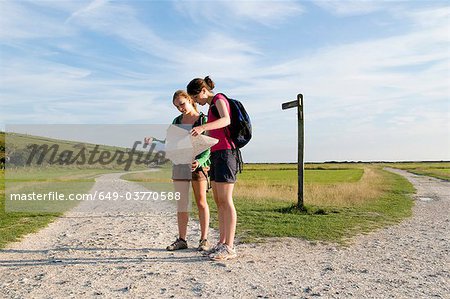 Female hikers check route on map