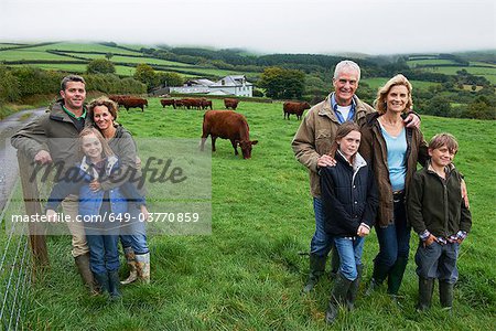 Family on farm in a field with cows