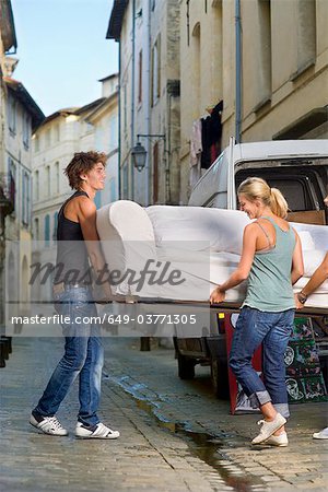 Couple moving sofa in street