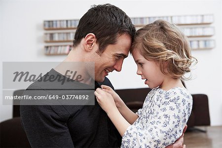 Girl buttoning up fathers shirt