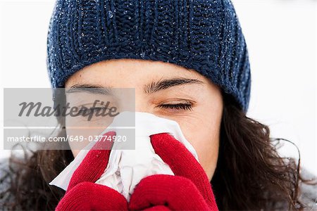 Woman wiping nose close-up