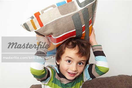 Boy throwing cushion