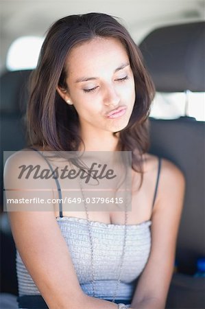 Offended young woman sitting in car