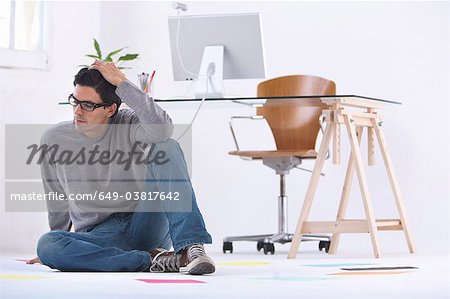 Man sitting on the floor in a office thinking