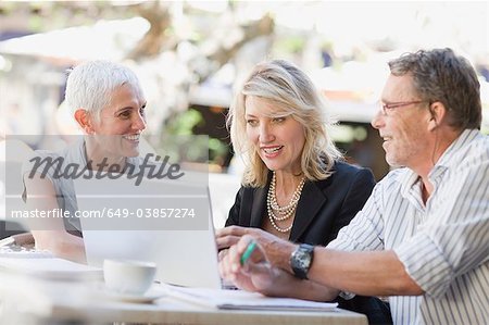 Business people using laptop outdoors