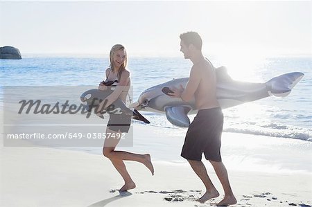 Couple playing with toys on beach