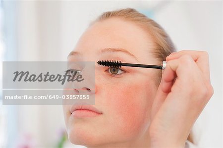 Teenage girl applying mascara