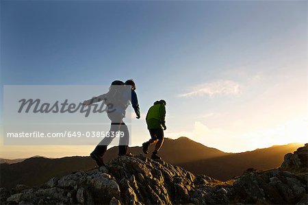 Men hiking on rocky mountainside Men hiking on rocky mountainside