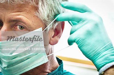 Dentist putting on face mask