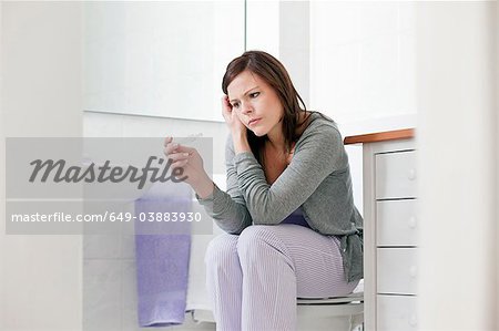 Concerned woman taking pregnancy test