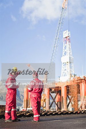 Workers talking on oil rig
