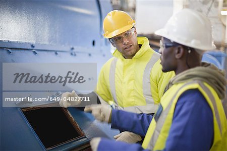 Workers examining machinery on oil rig