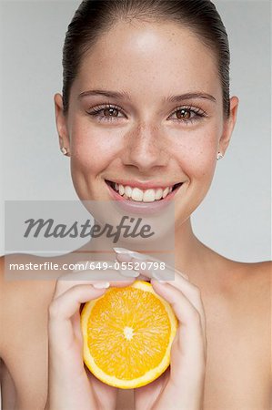 Woman holding halved orange
