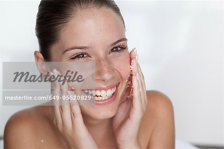 Woman scrubbing sugar on her face