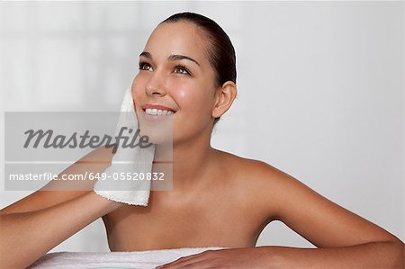 Woman scrubbing her face with cloth