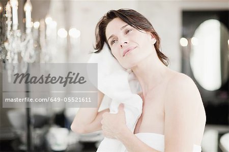 Woman drying her hair in bedroom