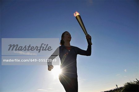 Athlete running with flaming baton