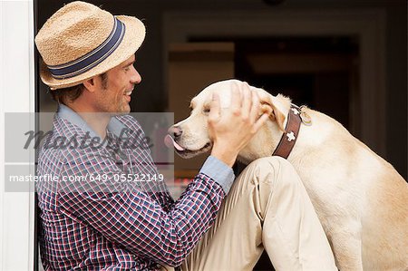 Man petting dog in window