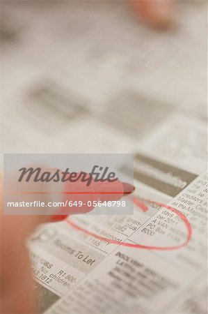 Close up of woman circling ads