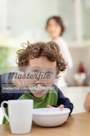 Boy eating breakfast in kitchen