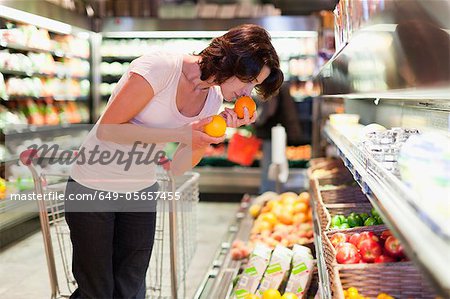 Woman smelling fruit at grocery store