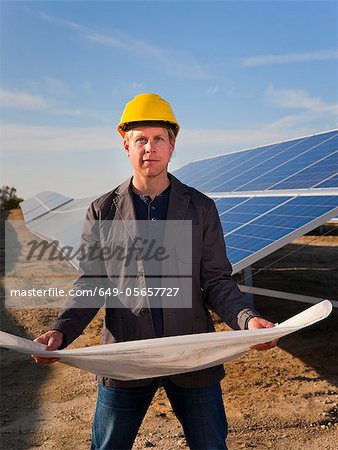 Architect with solar panels blueprints