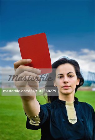 Woman holding red card on soccer pitch