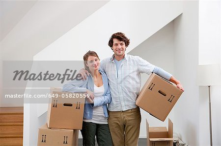 Couple carrying cardboard boxes
