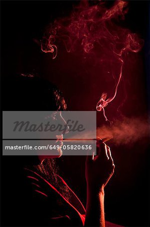 Illuminated profile of woman smoking