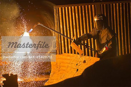 Welder at work in steel forge