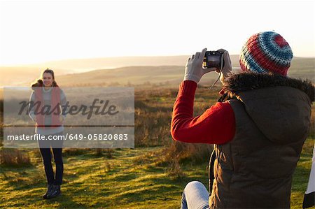 Woman taking picture of friend outdoors