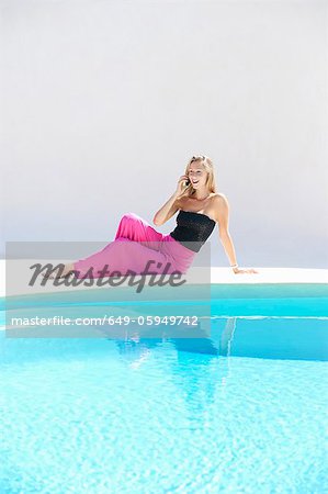 Woman using cell phone by pool