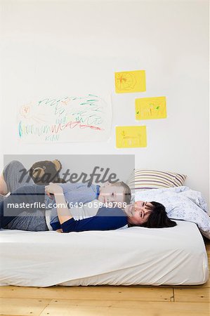 Mother and son relaxing on bed