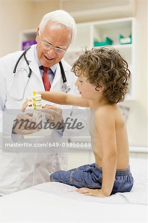 Doctor showing boy model in office