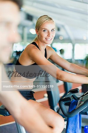 Woman using exercise machine in gym