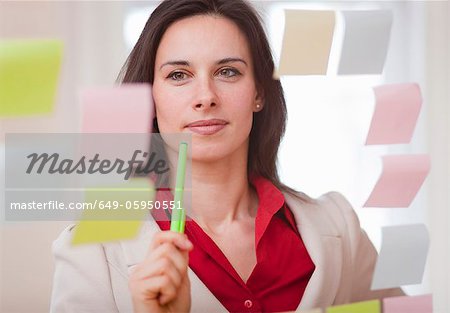 Businesswoman reading sticky notes