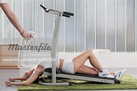 Woman laying on exercise machine